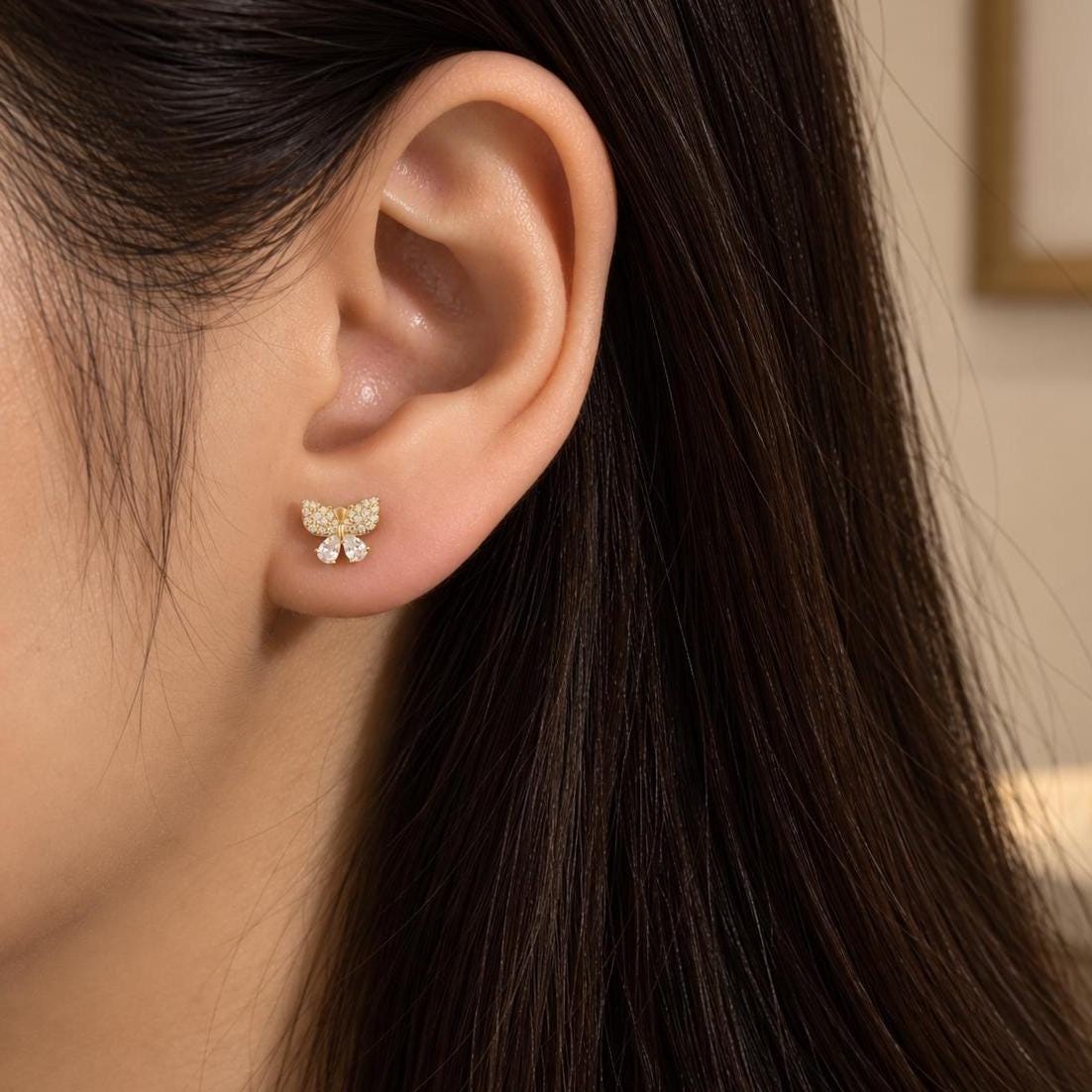 CZ butterfly stud earring worn on the ear