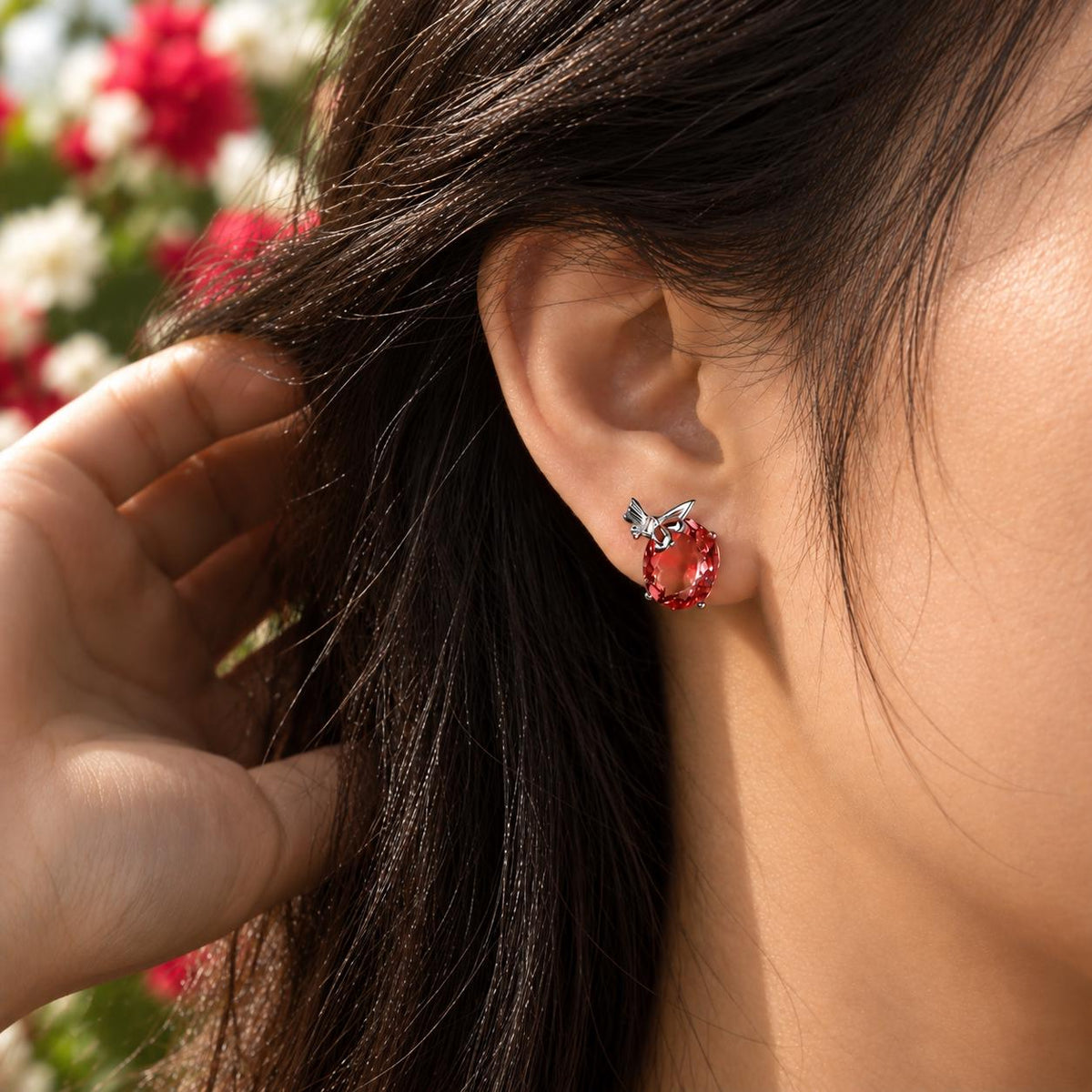 Red butterfly stud earring worn on the ear
