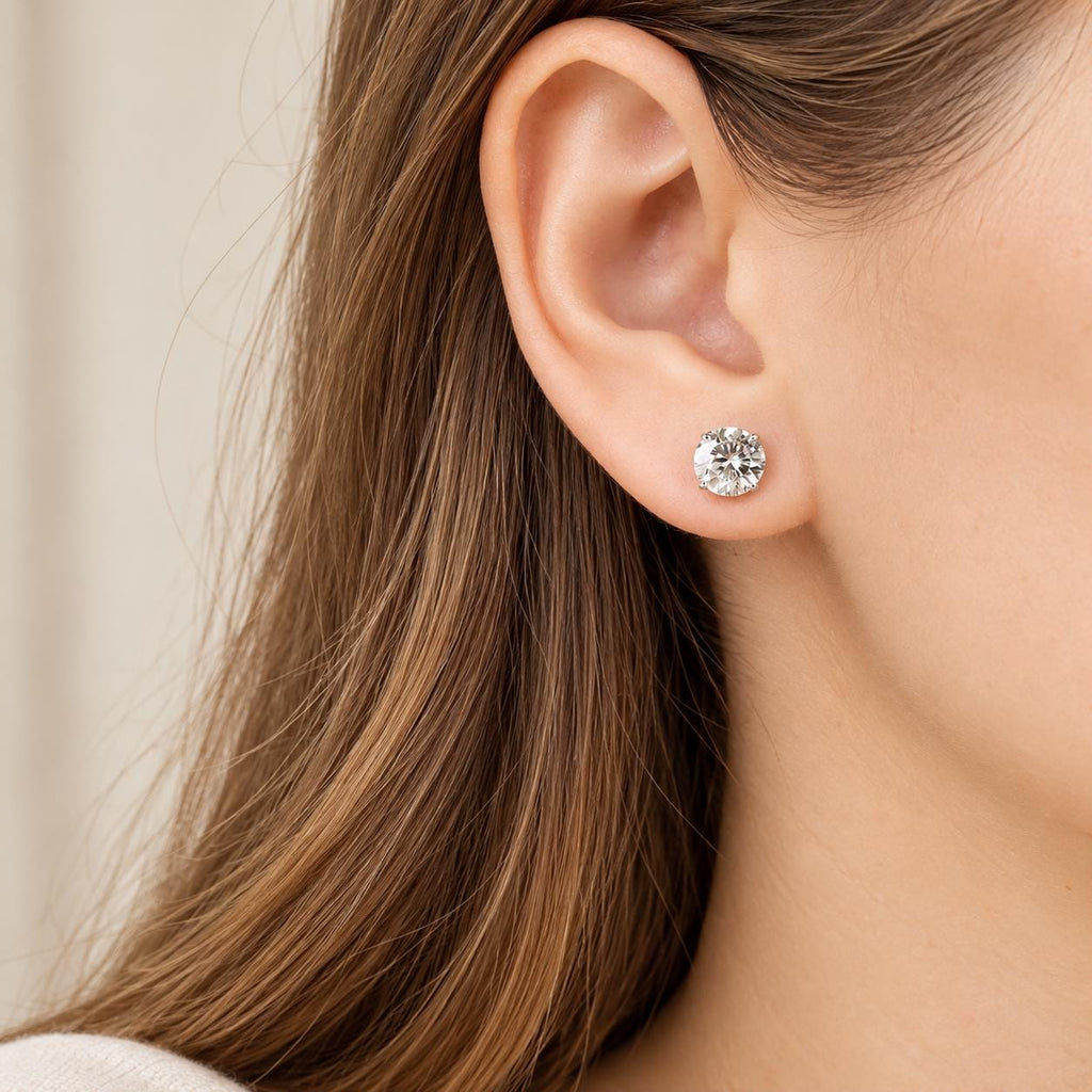 Model wearing round moissanite stud earrings - close-up